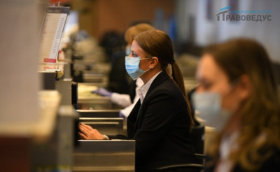 Девушка в маске, сидящая на рабочем месте